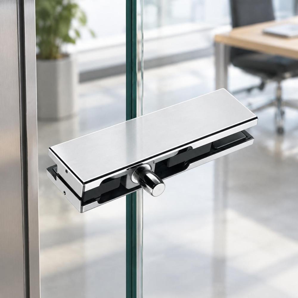 A close-up, high-angle shot of the stainless steel glass door lock, focusing on the locking bolt and internal housing